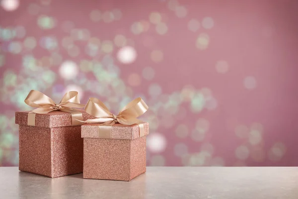 Beautiful Gift Boxes White Table Blurred Festive Lights Bokeh Effect — Stockfoto