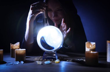 Kahin, karanlıkta masada geleceği tahmin etmek için kristal küre kullanıyor. Falcı.