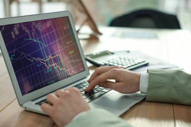 Broker working with laptop in office, closeup. Forex trading
