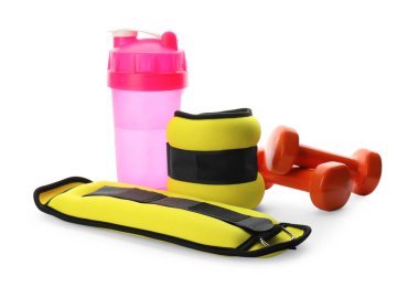 Beyaz arka planda şık tartma aletleri, dambıllar ve titretici.