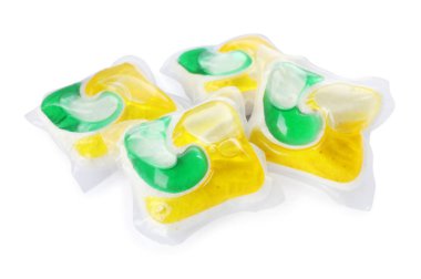 Beyaz arka planda birçok bulaşık deterjanı kapsülü