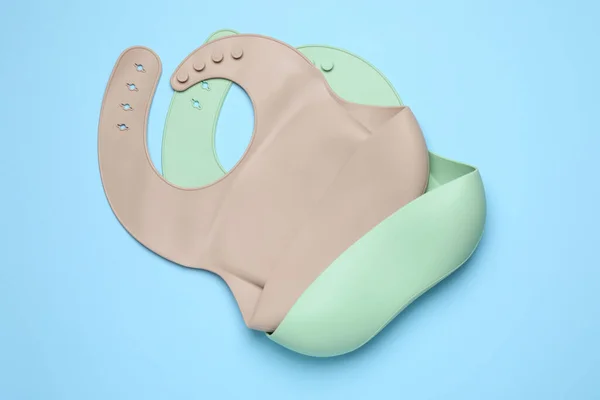 Two Silicone Baby Bibs Light Blue Background Top View First — Φωτογραφία Αρχείου