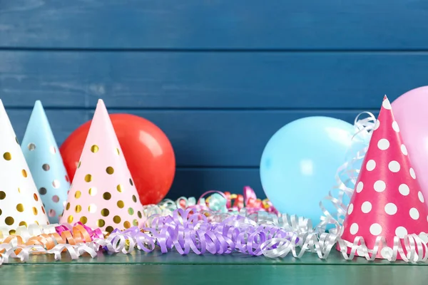 Colorful Serpentine Streamers Balloons Party Hats Green Wooden Table Space — ストック写真