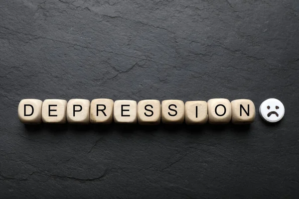 Word Depression Made Wooden Cubes Pill Sad Face Black Table — Stockfoto