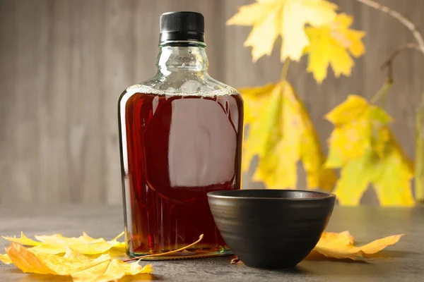 Bottle Tasty Maple Syrup Bowl Dry Leaves Light Grey Table — Φωτογραφία Αρχείου