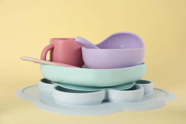 Set Plastic Dishware Beige Background Serving Baby Food — Φωτογραφία Αρχείου