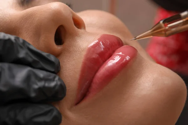若い女性のタトゥー サロン クローズ アップで恒久的な唇のメイクの手順を経る — ストック写真