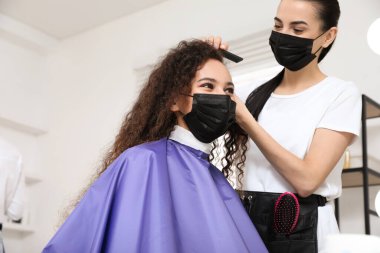 Müşteriyle kuaförde çalışan profesyonel stilist. Coronavirus karantinası sırasında kuaför servisi