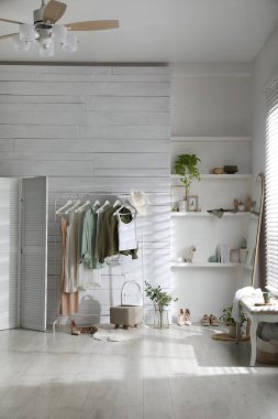 Soyunma odasında farklı şık giysiler, ayakkabılar ve dekoratif unsurlarla dizilin. İç tasarım