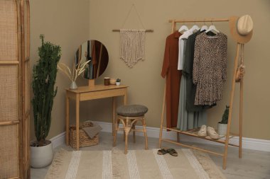 Modern soyunma odası. Giysi askısı, ahşap masa ve ayna.