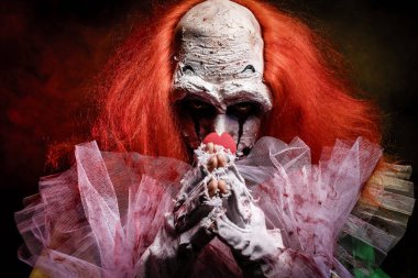 Karanlık arka planda korkunç bir palyaço. Cadılar Bayramı partisi kostümü