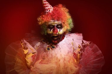 Karanlık arka planda korkunç bir palyaço. Cadılar Bayramı partisi kostümü