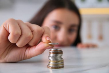 Masaya para istifleyen genç bir kadın, eline odaklan. Para tasarrufu