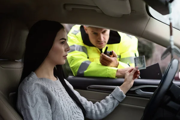 Kobieta Dająca Łapówkę Policjantowi Przez Okno Samochodu — Zdjęcie stockowe