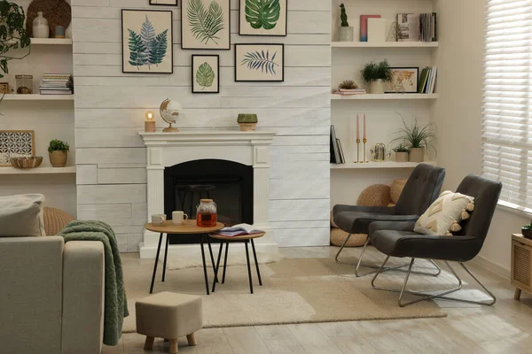 快適な椅子と装飾的な暖炉とスタイリッシュなリビングルームのインテリア — ストック写真