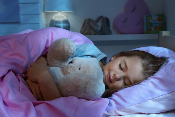 可爱的小女孩带着玩具熊睡在家里的床上 — 图库照片