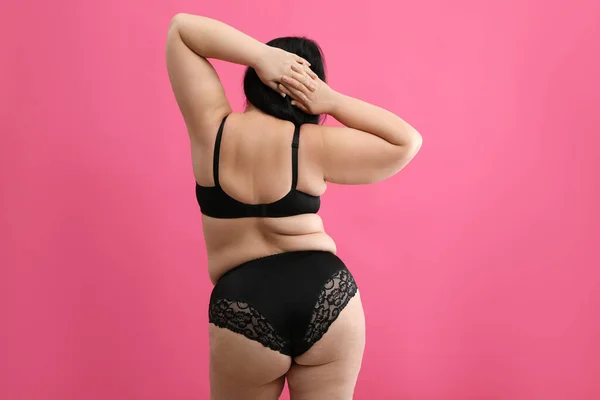 穿着粉色背景的黑色内裤的漂亮超重女人的背影 附加尺寸模型 — 图库照片