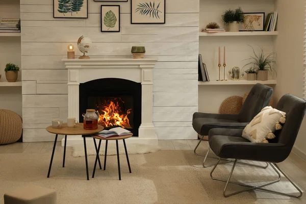 快適な椅子と装飾的な暖炉とスタイリッシュなリビングルームのインテリア — ストック写真