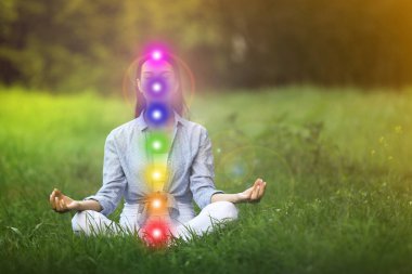 Yeşil çimenler üzerinde meditasyon yapan genç bir kadın. Yedi çakranın şeması, illüstrasyon