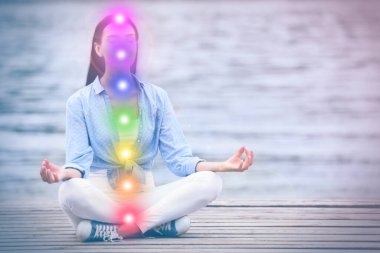 Nehir kenarında meditasyon yapan genç bir kadın. Yedi çakranın şeması, illüstrasyon