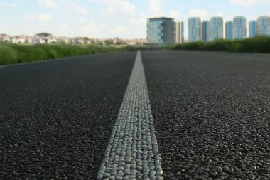 Boş asfalt yol ve güneşli bir günde güzel şehir manzarası