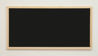 Beyaz duvarda asılı temiz siyah karatahta