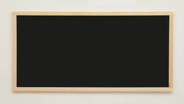 白い壁に掛けられたきれいな黒い黒板 — ストック写真