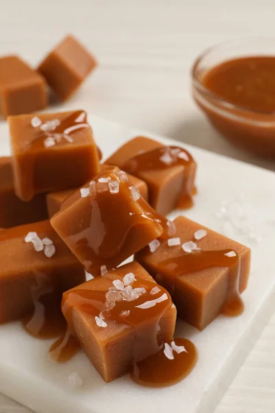 Doces Caramelo Saborosos Com Molho Sal Marinho Mesa Branca Close — Fotografia de Stock