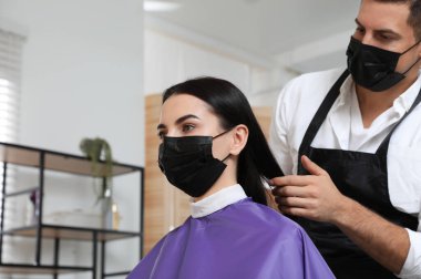 Müşteriyle kuaförde çalışan profesyonel stilist. Coronavirus karantinası sırasında kuaför servisi