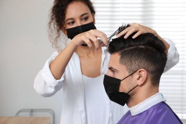 Müşteriyle kuaförde çalışan profesyonel stilist. Coronavirus karantinası sırasında kuaför servisi