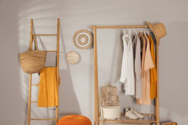 Modern giyinme odasının içinde şık kıyafetler, ayakkabılar ve sırt çantası var.