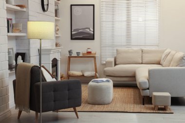 Rahat kanepesi, koltuğu ve dekoratif şöminesi olan şık bir oturma odası.