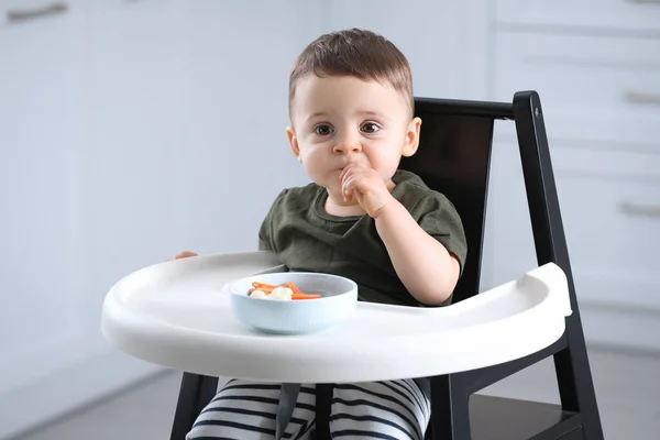 かわいい赤ちゃん食べる健康食品で高い椅子で自宅 — ストック写真