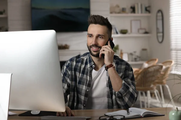 Ofisteki Masada Bilgisayarla Çalışan Bir Adam Telefonla Konuşuyor — Stok fotoğraf