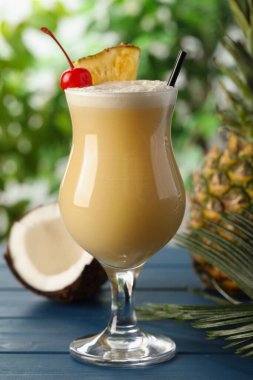 Lezzetli Pina Colada kokteyli ve açık mavi ahşap masa malzemeleri.
