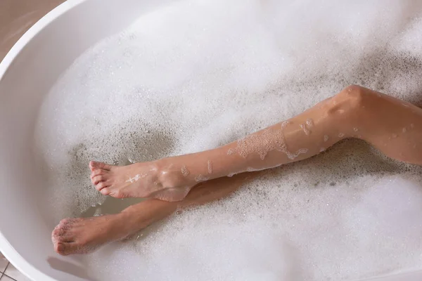 女性はバスタブのシャワージェルでお風呂に入る トップビュー — ストック写真