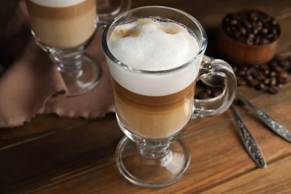 Νόστιμο Latte Macchiato Και Κόκκους Καφέ Ξύλινο Τραπέζι — Φωτογραφία Αρχείου