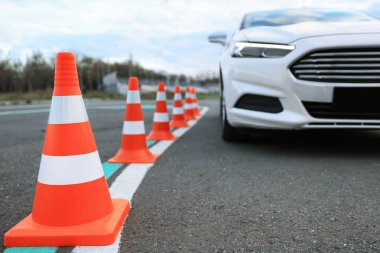 Test pistinde trafik konileri olan modern bir araba, yakın plan. Sürücü kursu