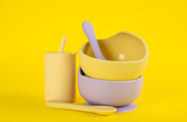 Sarı arka planda plastik bulaşık takımı. Bebek maması servisi.