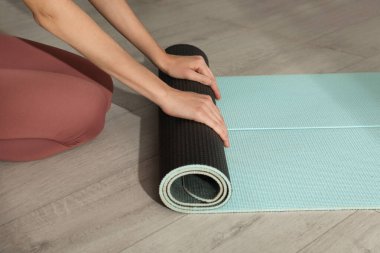 Yoga paspası yuvarlanan kadın, yakın plan.