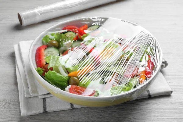用塑料食物包裹在白色木制桌子上的新鲜沙拉碗 特写镜头 — 图库照片