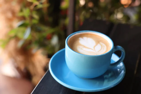 屋外のカフェで木製のテーブルの上に泡と香りのコーヒーのセラミックカップ テキストのスペース — ストック写真