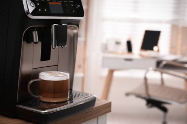Ofisteki masada cam bardak kahve ile modern espresso makinesi. Metin için boşluk