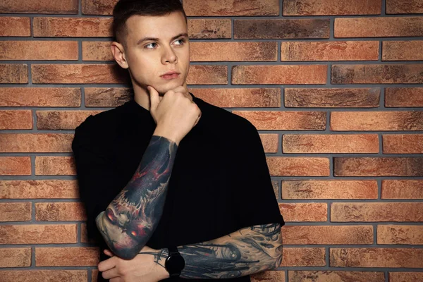 Ung Man Med Tatueringar Nära Tegelvägg — Stockfoto