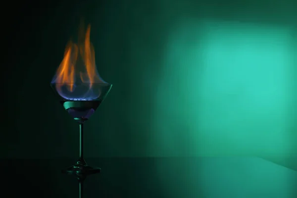 緑の背景にウォッカの炎とカクテルガラス テキストのためのスペース — ストック写真