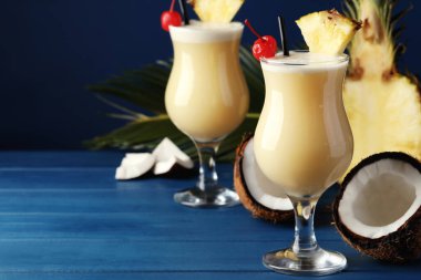 Lezzetli Pina Colada kokteylleri ve mavi ahşap masa malzemeleri, metin için yer