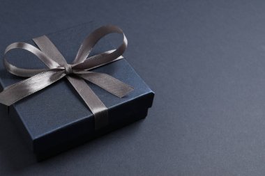 Siyah arkaplanda fiyonklu güzel hediye kutusu, metin için boşluk