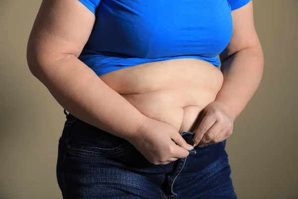 Übergewichtige Frau Versucht Enge Jeans Auf Hellbraunem Hintergrund Knöpfen Nahaufnahme — Stockfoto
