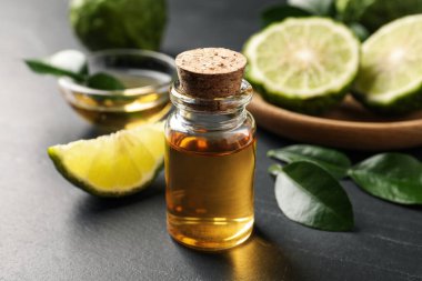 Bir şişe bergamot esaslı yağı karanlık masanın üzerinde, yakın plan.