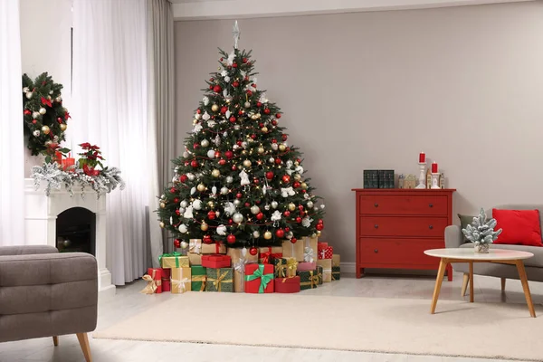 아름다운 크리스마스 트리와 화려하게 장식된 거실의 벽난로 근처의 선물들 — 스톡 사진